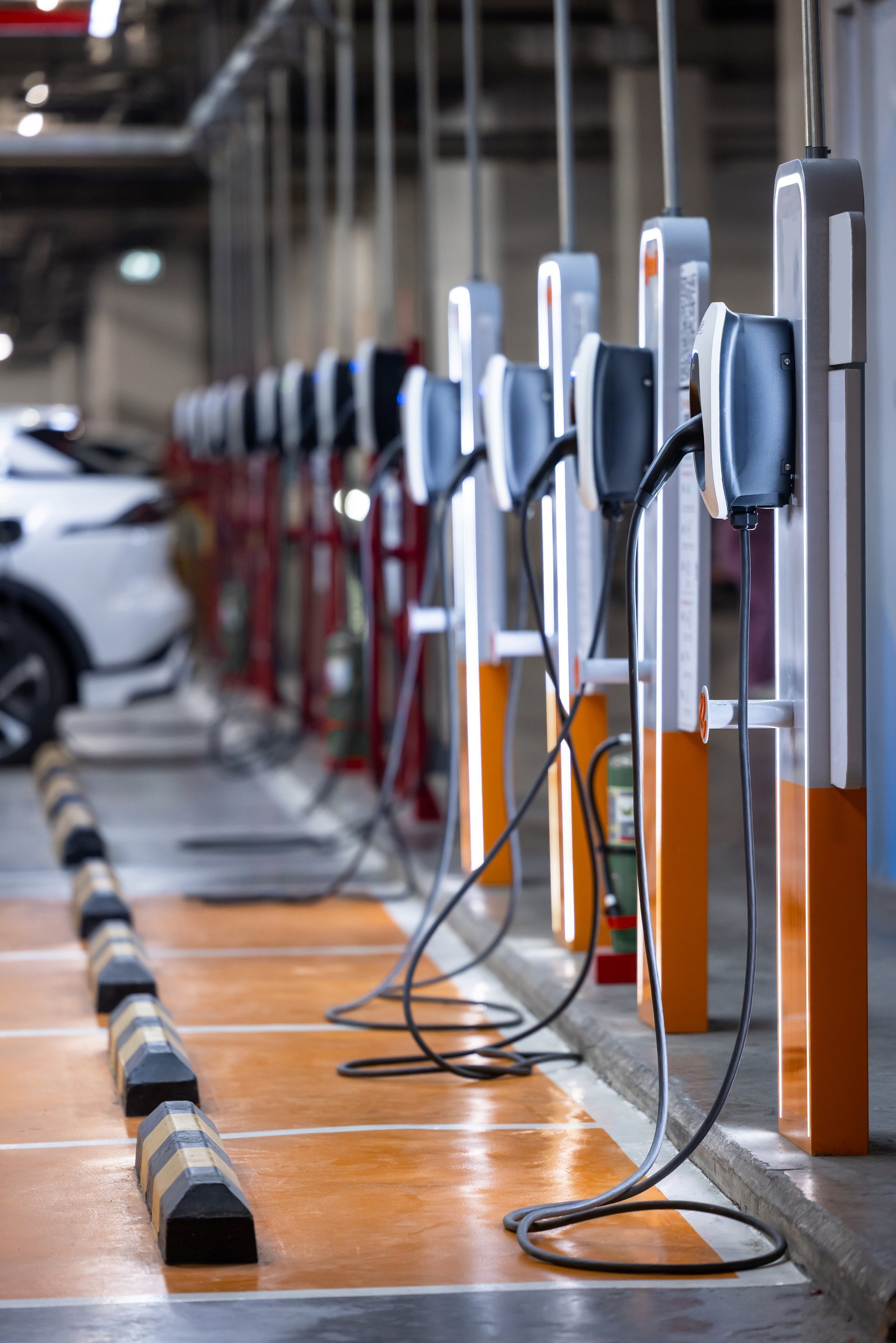 EV charging station and electric car, clean energy charging point at car parking lot.