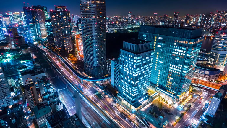 Long exposure photography of a city with buildings and streets with moving lights.