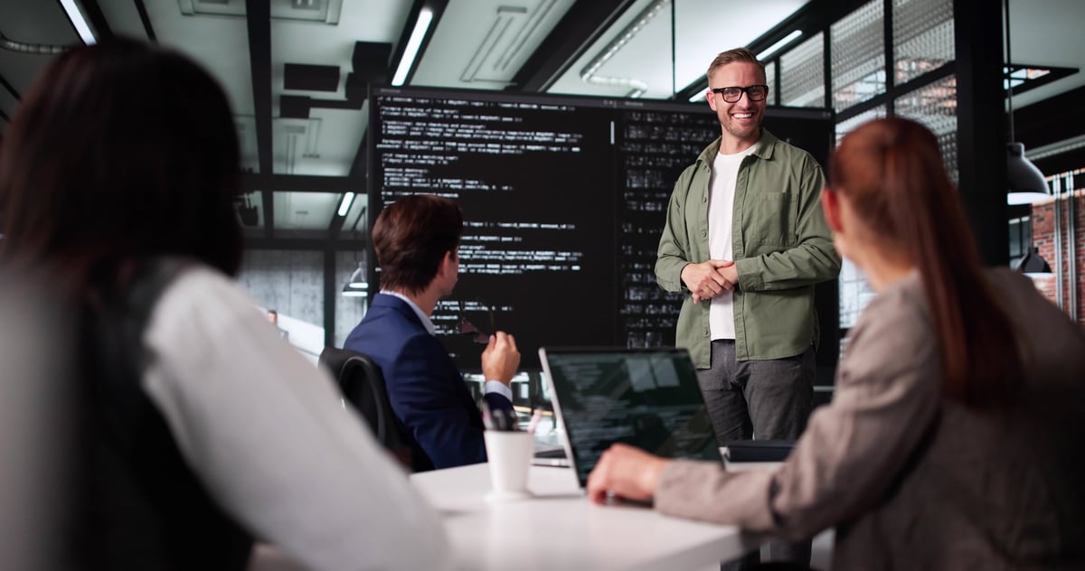 Technician Leading Software Presentation At Business Meeting With Diverse Team