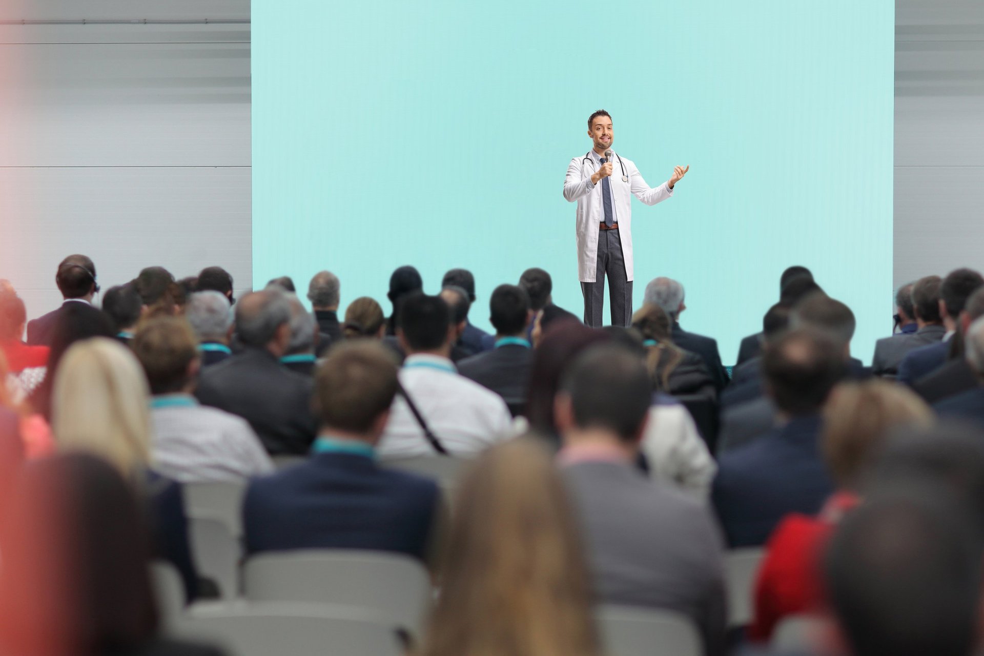 Doctor presenting on stage at a medical conference.